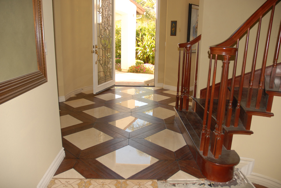 Entryway to a home with ornate tile flooring and a wooden staircase